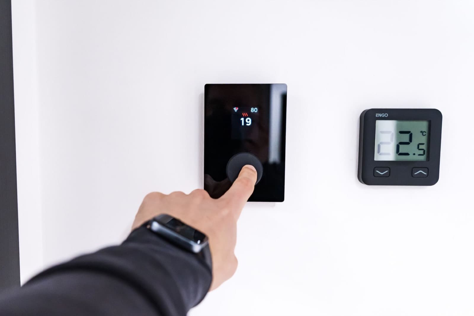 Digital smart thermostat on a wall controlling home temperature